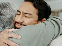 Adult son hug and mother in house