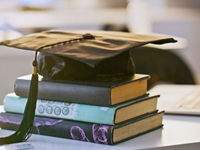Graduation cap books and laptop