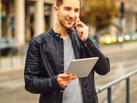 Young man on the phone holding a tablet