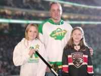 Nate Kolle and his daughters, being honored with the Securian Stick Tap Salute